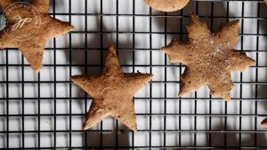 Just baked healthy gingerbread cookies cooling on a black wire cooling rack.