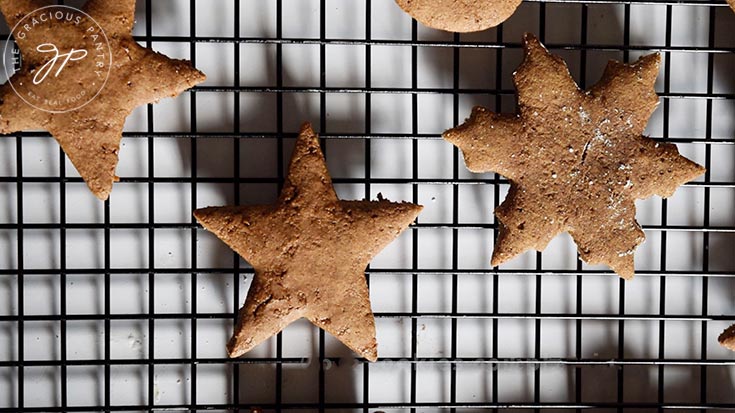 Just baked healthy gingerbread cookies cooling on a black wire cooling rack.