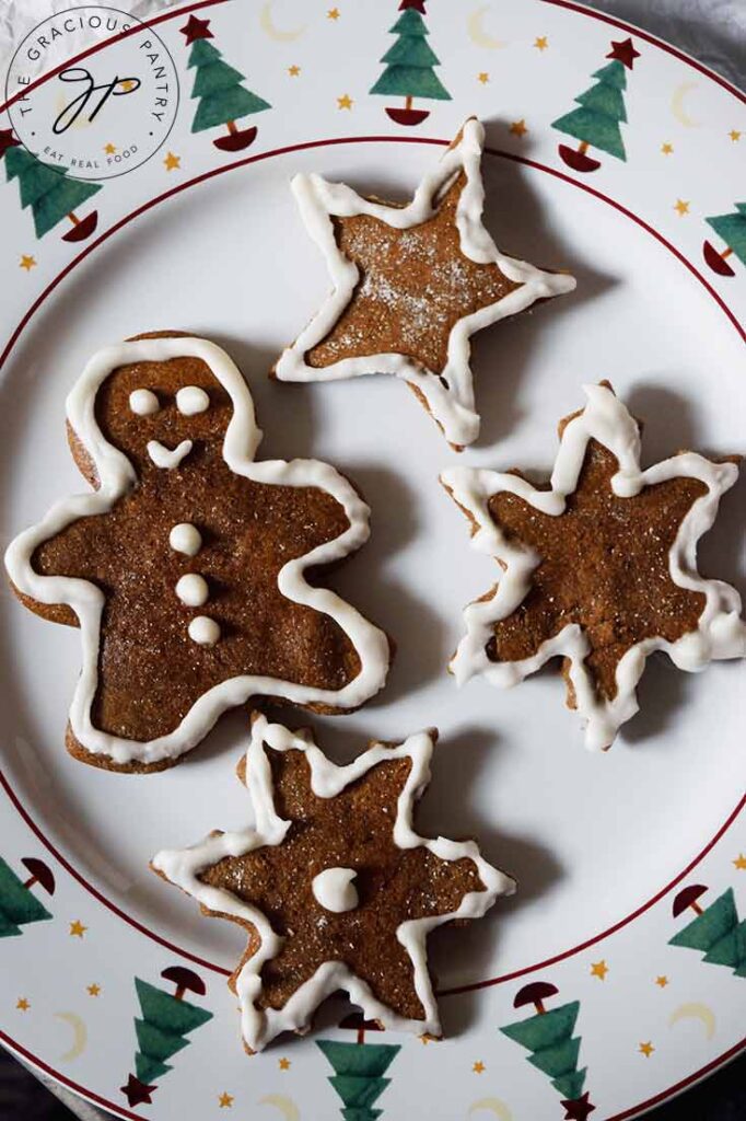 Decorated healthy gingerbread cookies laying on a Christmas plate.