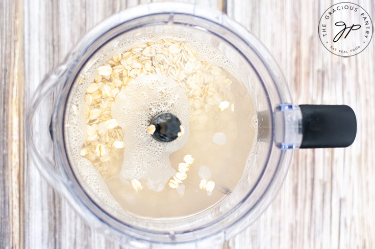 All the oat milk ingredients sitting unblended in a blender tumbler.