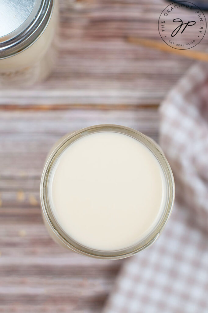 An overhead shot looking down into an open canning jar filled with oat milk.