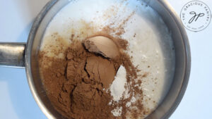Milk, cocoa powder and arrowroot powder in a small pot.