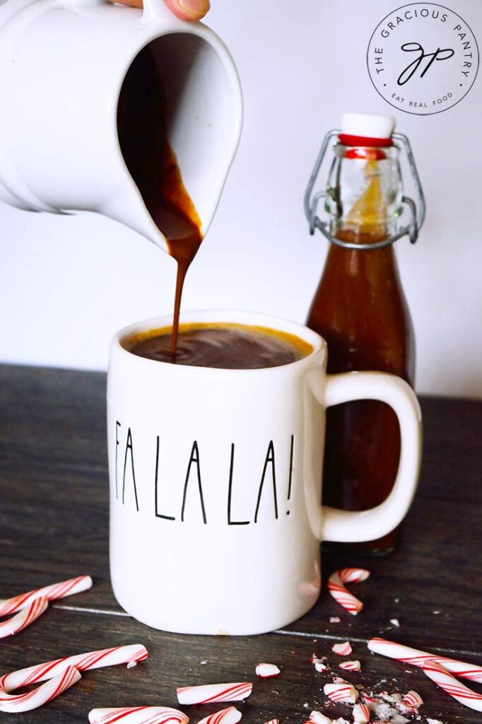 Protein Peppermint Mocha Creamer being poured into a mug of coffee from a small, white pitcher.