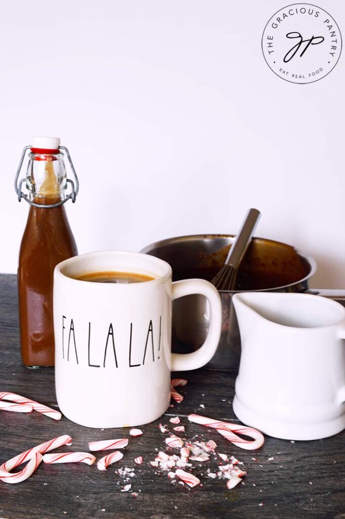 A group shot of all the containers used in the making of this Protein Peppermint Mocha Creamer Recipe. A mug, white pitcher, capped bottle and small pot.