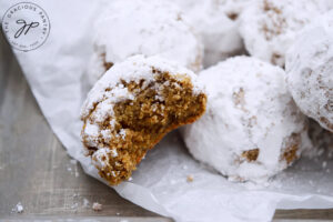 The finished Pfeffernusse Cookies in a pile. One has a bite taken out of it.