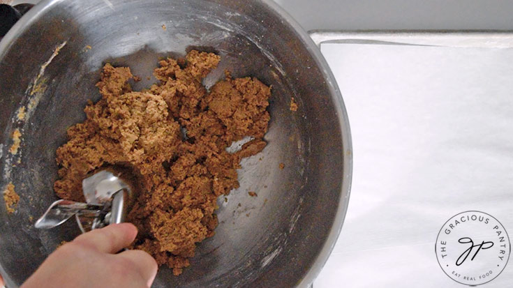 Cookie dough being scooped with a dough scooper.