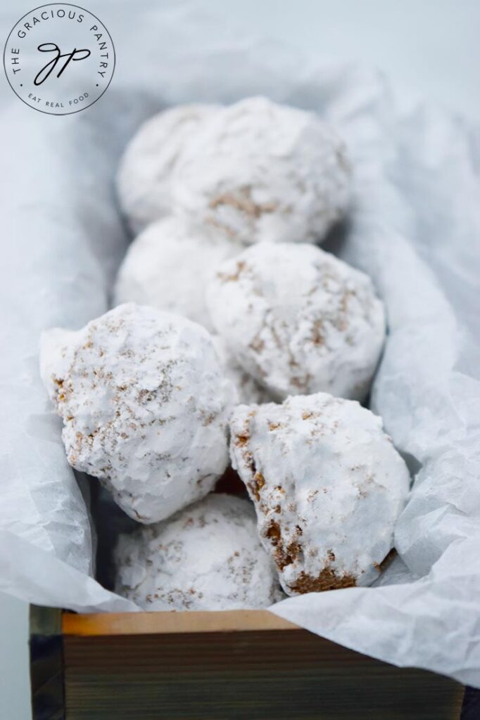 A parchment-lined, wooden box filled with Pfeffernusse Cookies.