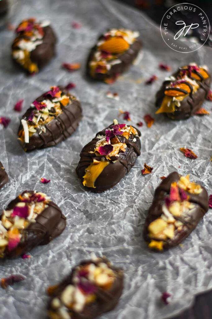 Stuffed Dates sitting on a piece of wrinkled parchment paper and topped with dried rose petals.