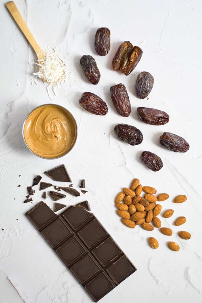 Ingredients for this stuffed dates recipe all sitting together on a white background.