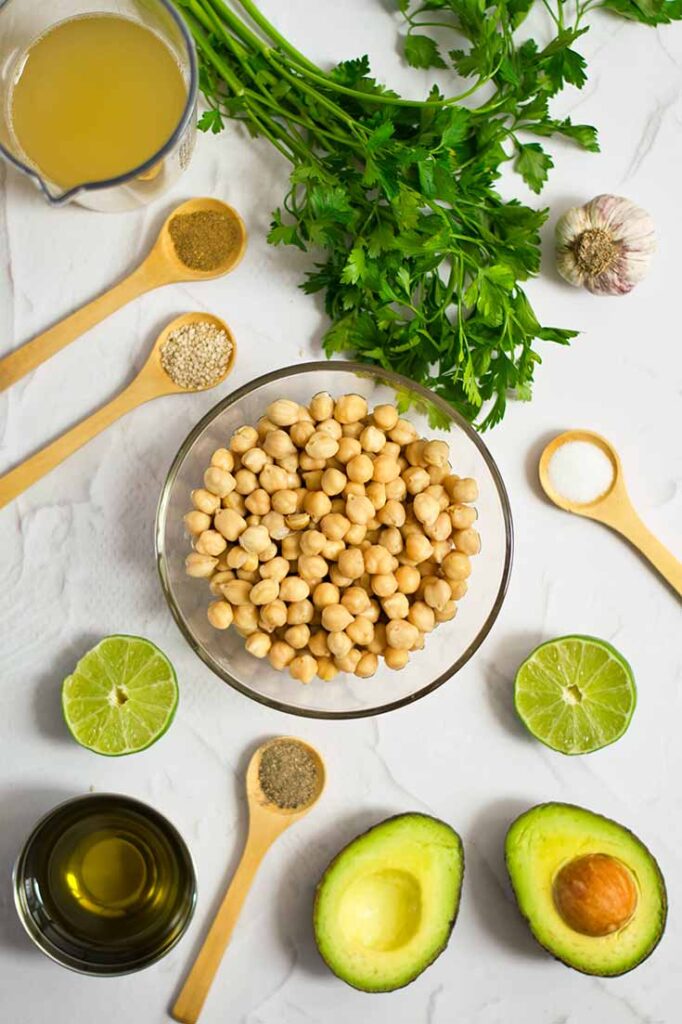 The ingredients for this Avocado Hummus Recipe collected on a white countertop.