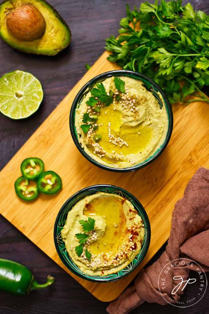 An overhead view looking down into two black bowls filled with Avocado Hummus.