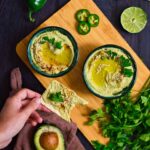 A cracker spread with Avocado Hummus.