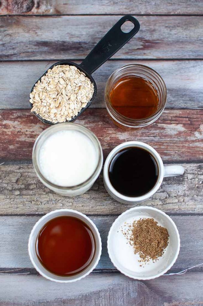 All the ingredients for this Coffee Overnight Oats Recipe collected on a wooden table in separate bowls.