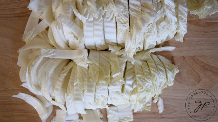 Chopped cabbage laying on a wooden cutting board.