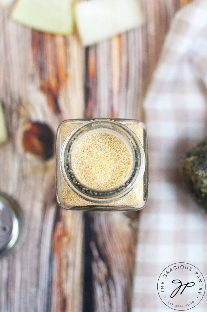 An overhead view looking down into a spice jar filled with homemade onion powder.