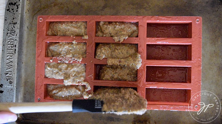 Filling an oiled bar pan with Low Carb Snack Bars batter.