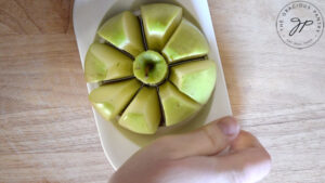 Cutting an apple with an apple slicer.