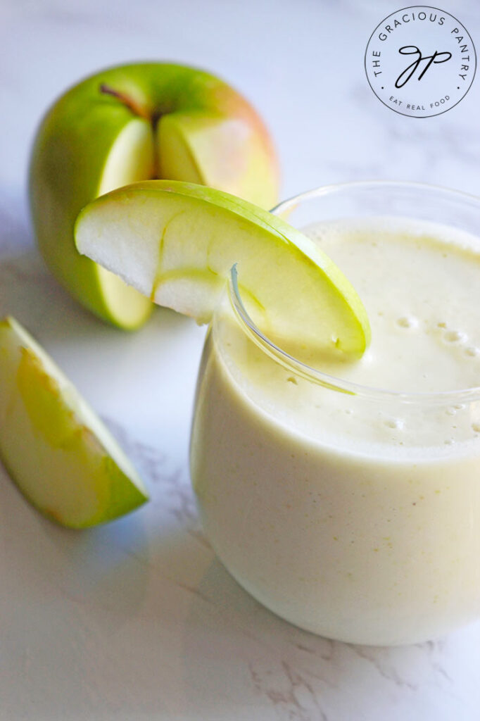 A side view of a glass filled with this Tart Green Apple Smoothie Recipe.