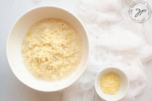 The ingredients for this Cauliflower Fritters Recipe mixed together in a white bowl.