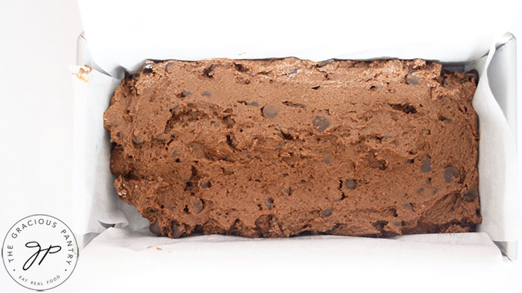 Chocolate Pumpkin Bread dough leveled out in a parchment lined loaf pan.