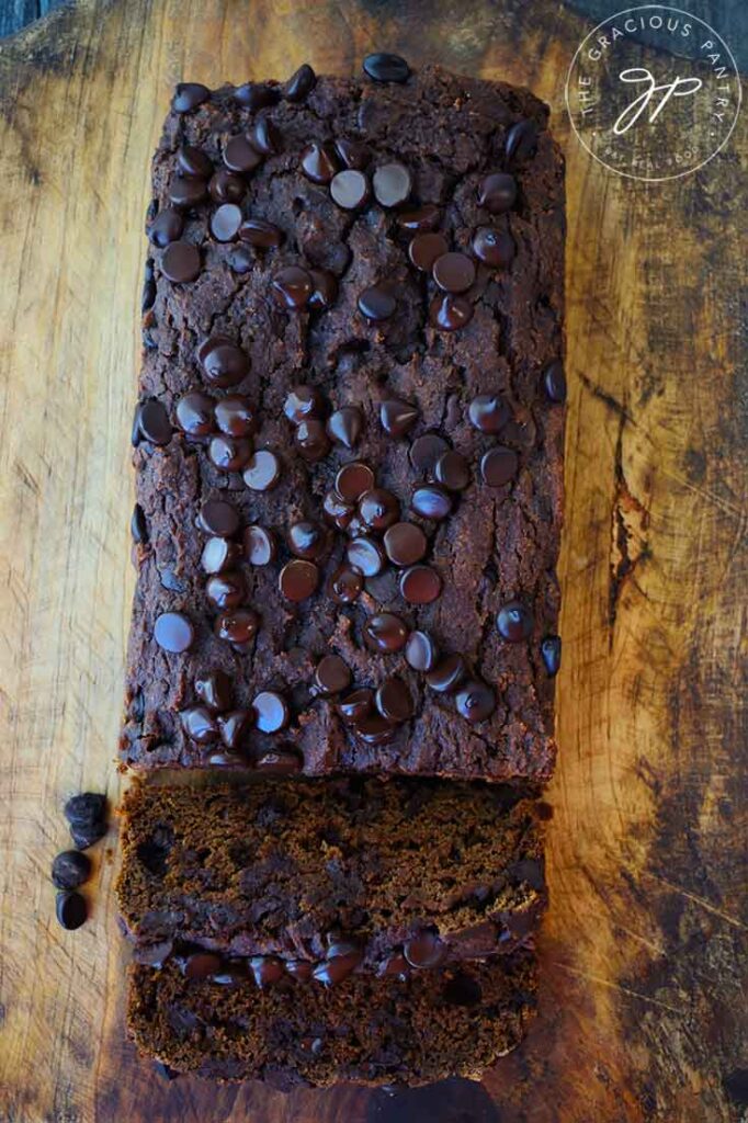 And overhead view of a loaf of Chocolate Pumpkin Bread with two slices laying cut from one side.