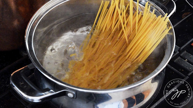 Linguini noodles cooking in a pot of boiling water.
