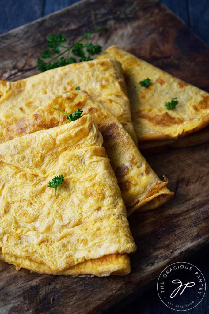 A sideview of egg wraps, made with this egg wrap recipe, folded on a cutting board.