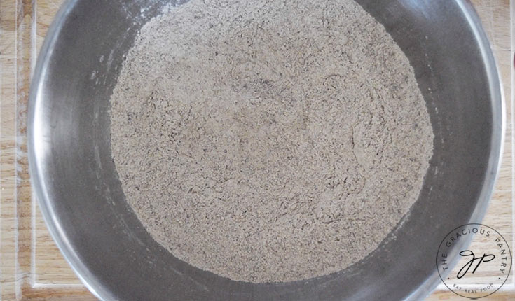 A flour mixture sitting in a stainless steel mixing bowl.