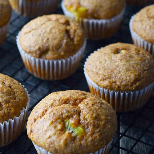 Kiwi muffins sitting on a wire cooling rack.