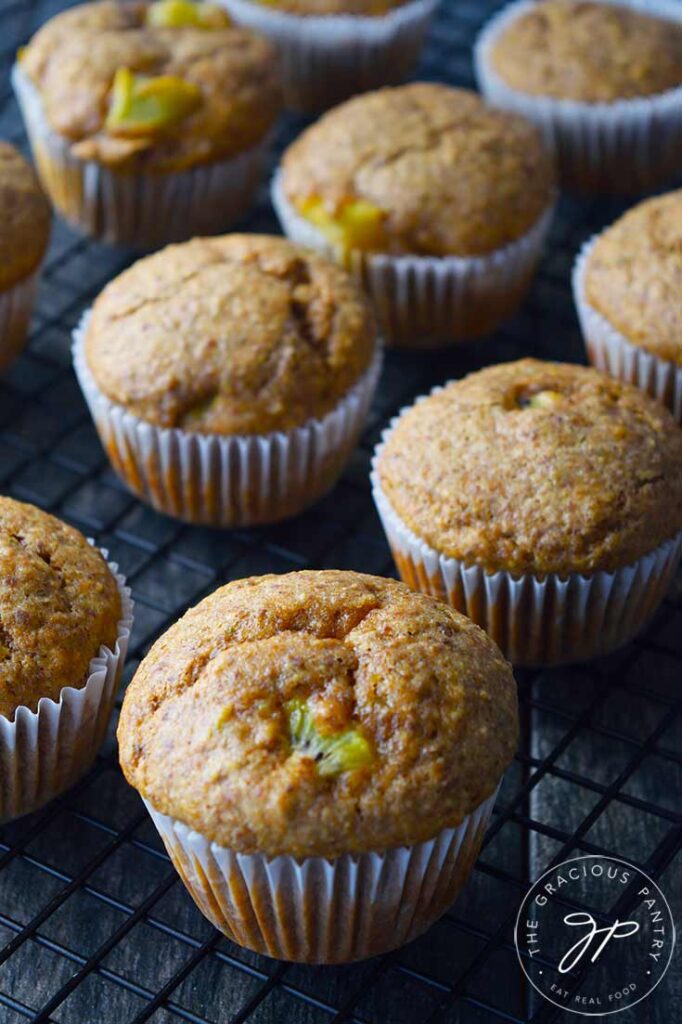 Kiwi muffins sitting on a wire cooling rack.