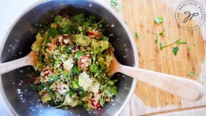 The Avocado Quinoa Salad mixed in a stainless steel mixing bowl.