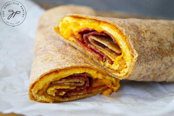 The finished Bacon And Egg Wrap laying on a piece of parchment paper.
