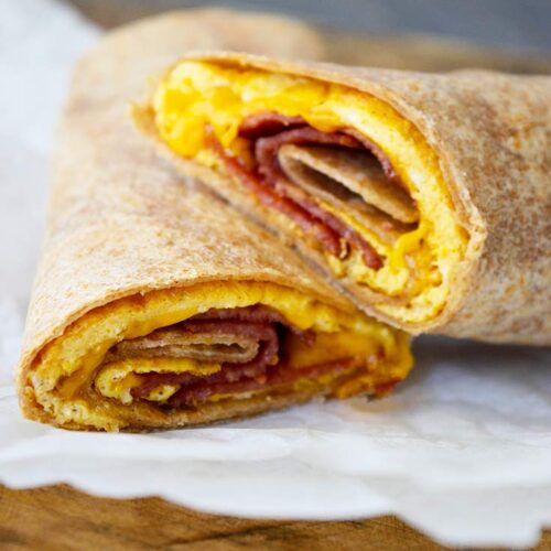 An up close view of a cut Bacon And Egg Wrap. You can see the egg, cheese and bacon.