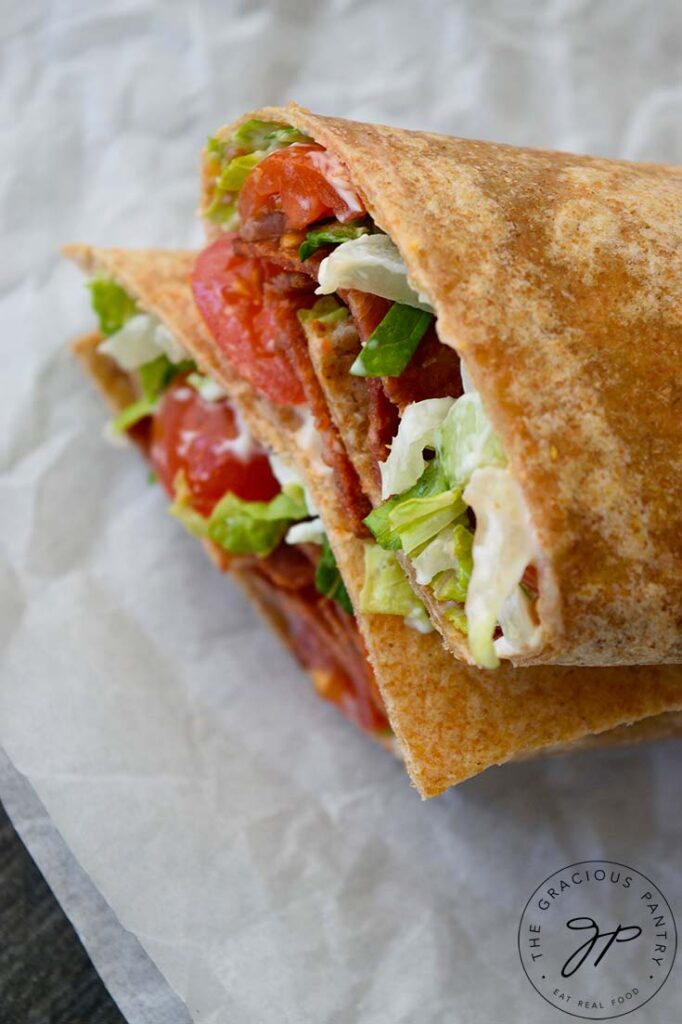 An overhead view looking down on a cut BLT Wrap that has been stacked up on a piece of parchment paper.