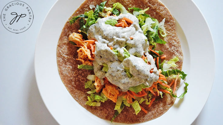 Ranch dressing drizzled over the open Buffalo Chicken Wrap.