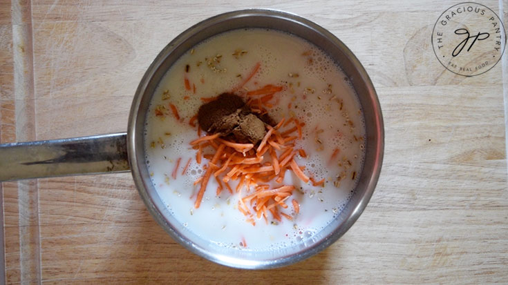 A pot filled with all the Carrot Cake Oatmeal Recipe ingredients, ready to cook.