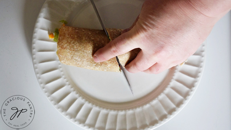 Slicing a Cobb Salad Wrap in half.