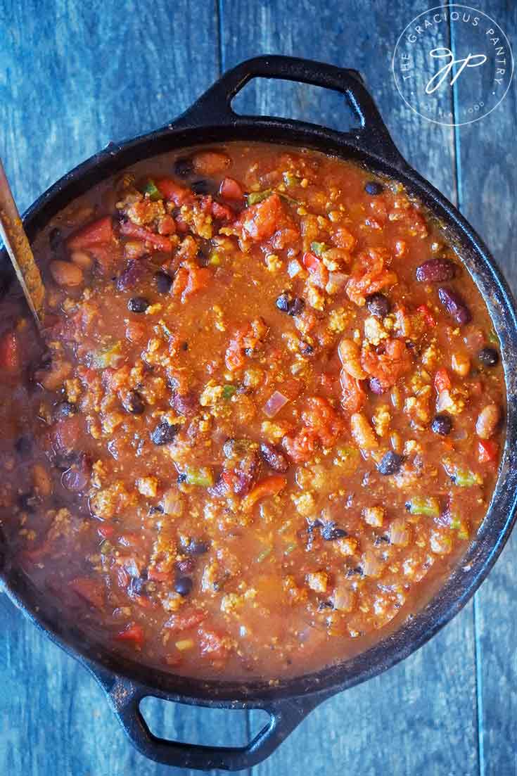 An overhead view looking down into a cast iron dutch oven filled with Dutch Oven Chili.