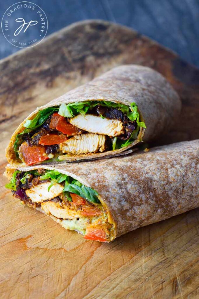 A front view of a sliced fajita wrap, laying on a cutting board.