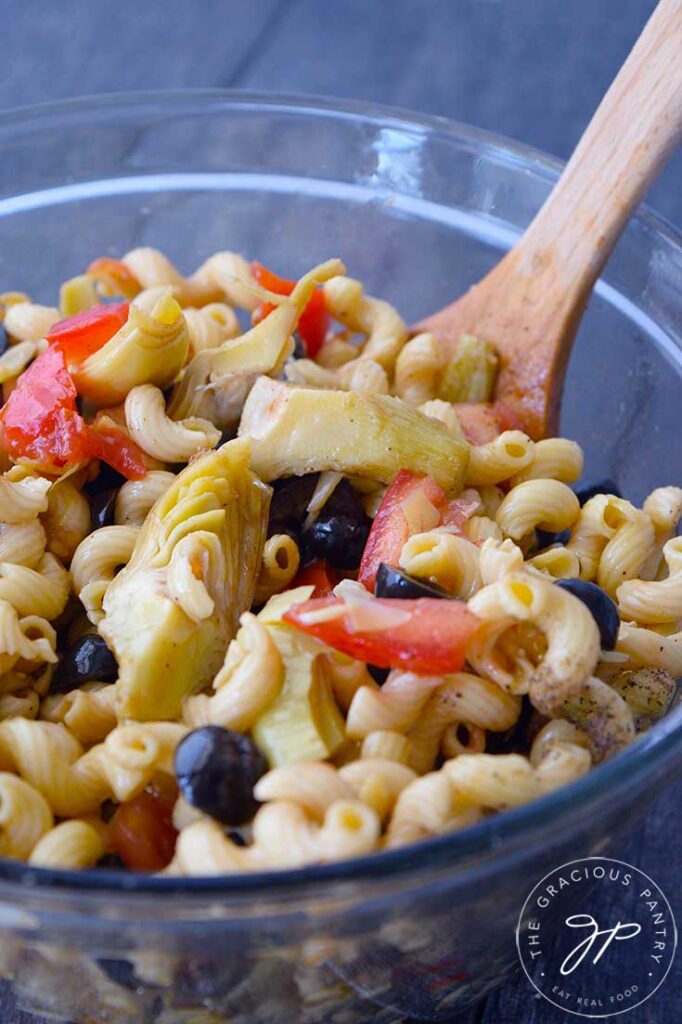 And up close view of a glass bowl holding just-made Greek Pasta Salad.