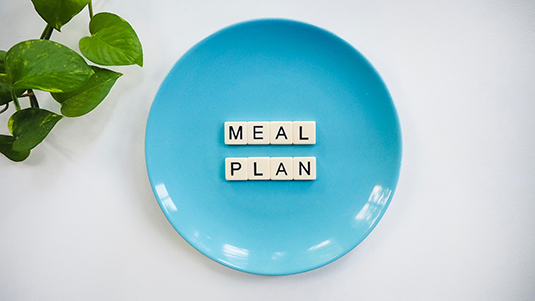A blue plate with letter blocks spelling out "meal plan".
