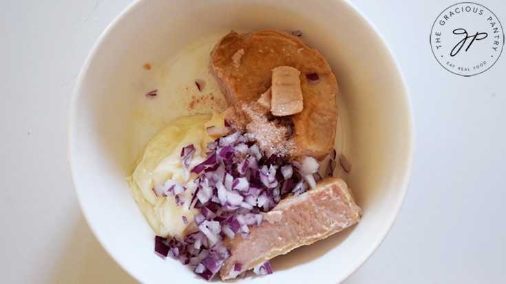 Tuna wrap ingredients in a white mixing bowl just before mixing.