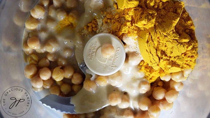 All the Turmeric Hummus Recipe ingredients sitting in a food processor bowl.