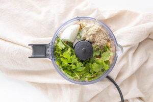 All the ingredients for this Air Fryer Falafel Recipe sitting in a food processor on a white background.