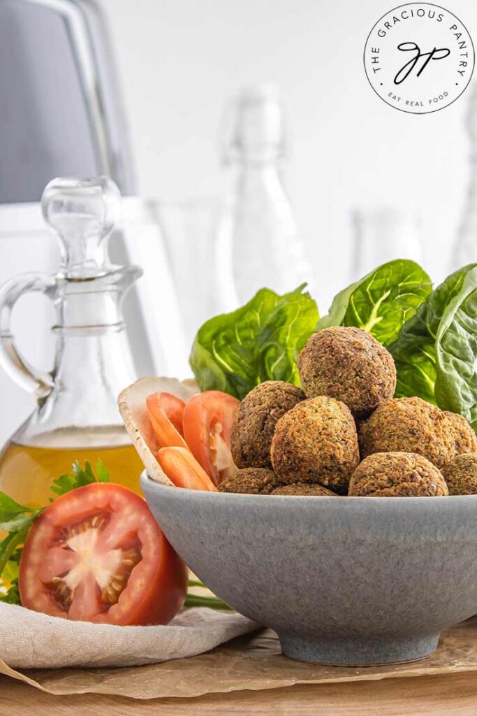 A side view of a gray bowl filled with falafel balls.