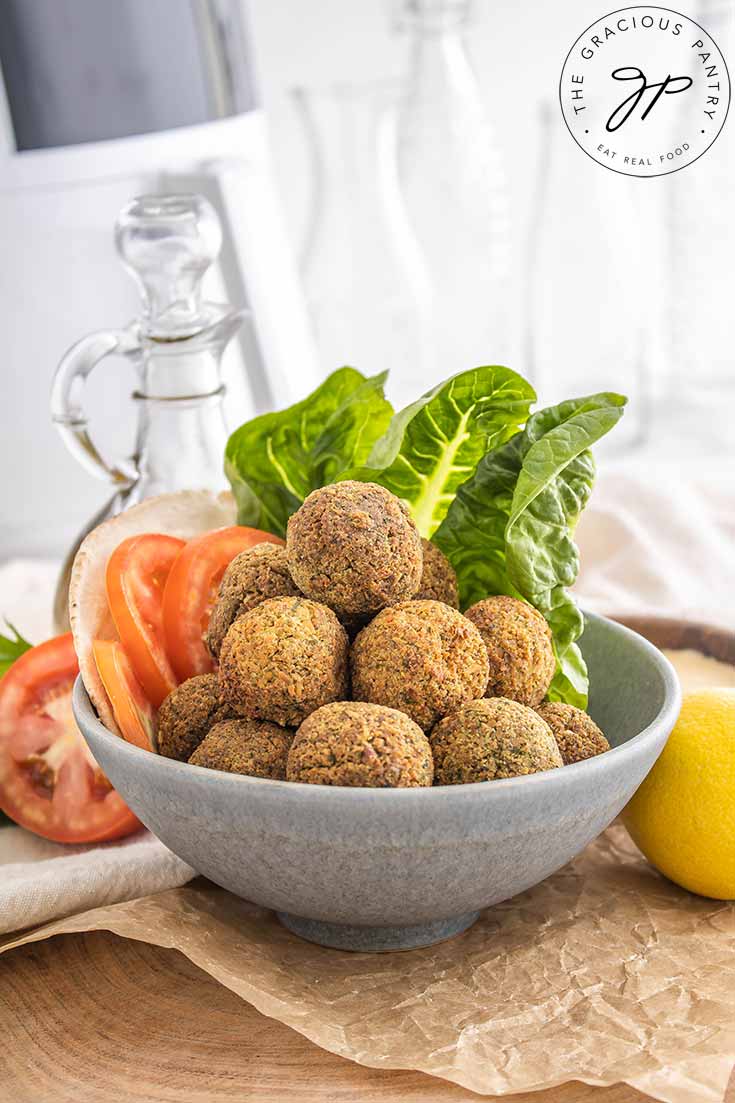 A front view of a gray bowl piled high with falafel balls.