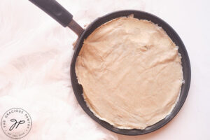 A crepe pan with a cooked crepe on it.