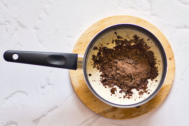 Chopped chocolate added to a pot of cream.