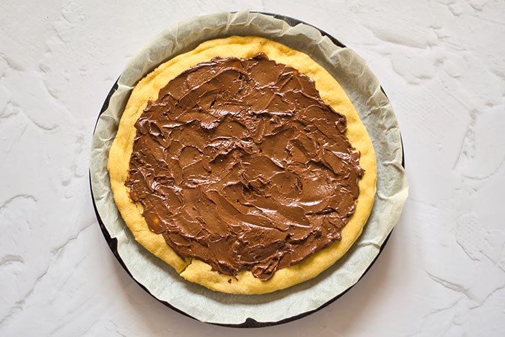 Chocolate sauce spread over pizza crust.