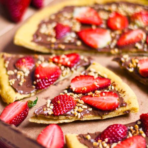 A chocolate pizza, sliced and sitting in a cardboard pizza box.